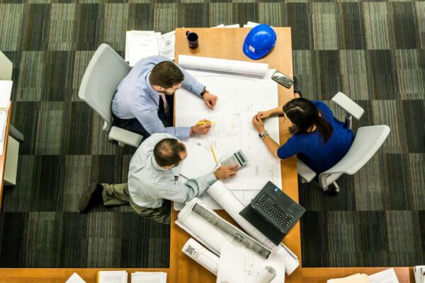 Top view of a team working on construction plans in an office setting.