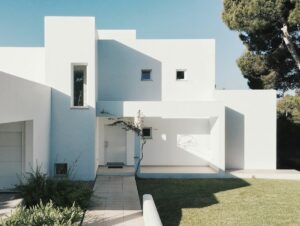 white concrete house near green tree during daytime