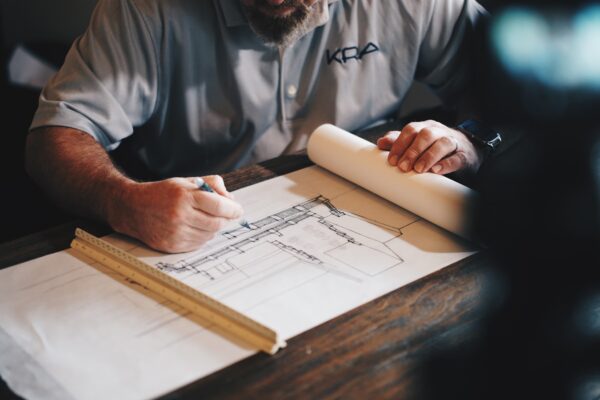 An architect working on a draft with a pencil and ruler