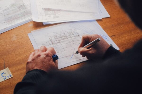 Honorarios arquitectura: cuánto cuestan y qué factores los influyen person writing on white paper