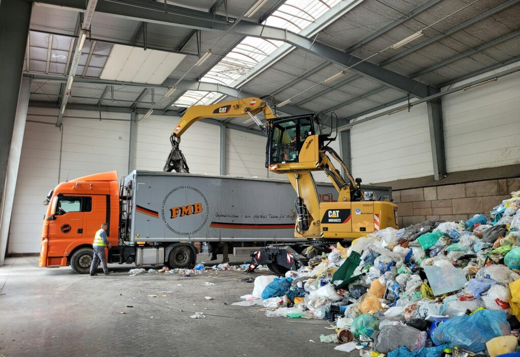 a large truck with a load of trash in a warehouse